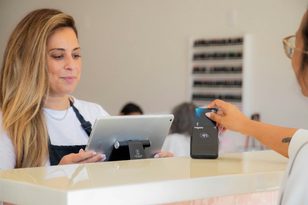 Salon front desk booking a client appointment on a tablet