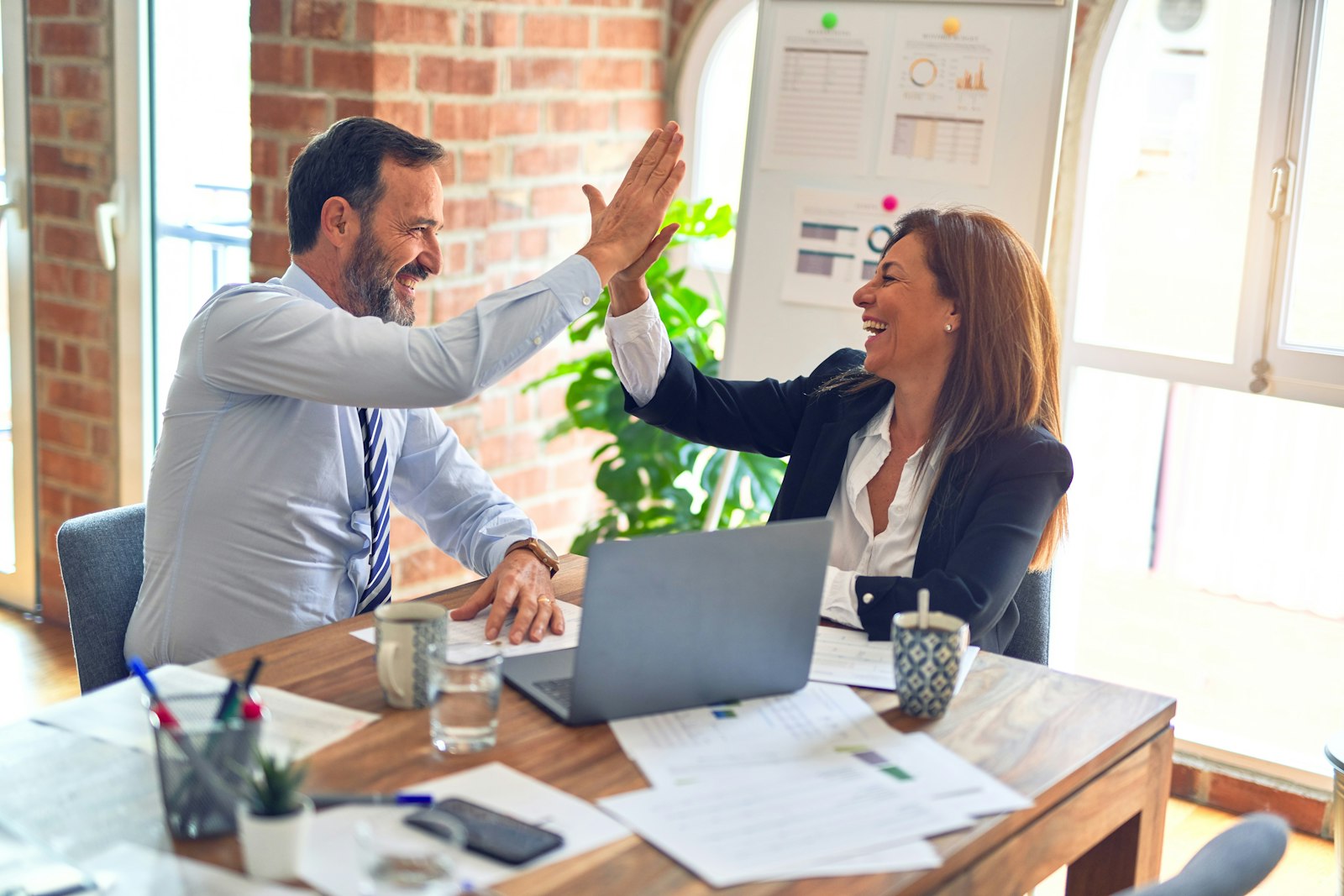 Business partners celebrating a booked job after an after-hours call